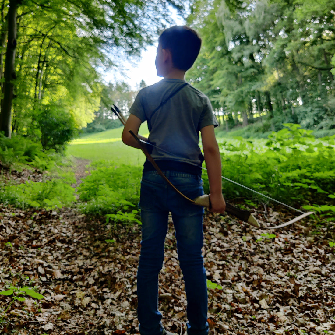 Junge mit Abowllon Bogen auf Waldweg